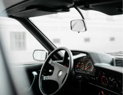 A steering wheel and dashboard seen through the open door
