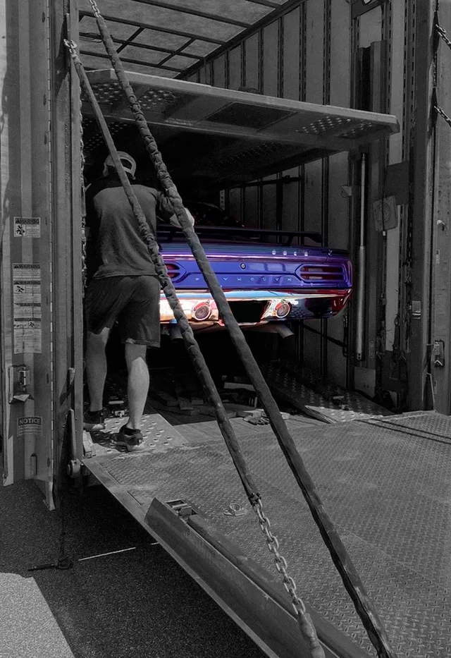 A car being loaded into a closed trailer