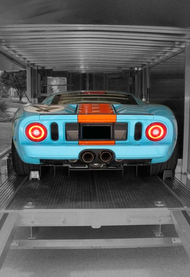 A single sports car strapped down alone inside a trailer