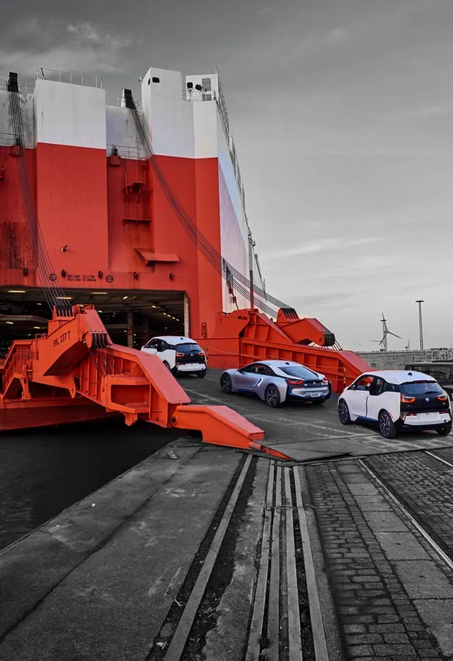 The loading ramp of a car carrier with cars waiting behind it